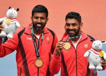 India's gold medallists Divij Sharan (R) and Rohan Bopanna (L) pose for photographers during the medal ceremony for men's doubles tennis at the 2018 Asian Games in Palembang on August 24, 2018. / AFP PHOTO / ADEK BERRY