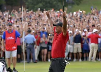 Tiger Woods celebrates after picking up his putt for par on the 18th green to win the final round of the Tour Championship golf tournament Sunday, Sept. 23, 2018, in Atlanta. (Hyosub Shin/Atlanta Journal-Constitution via AP)