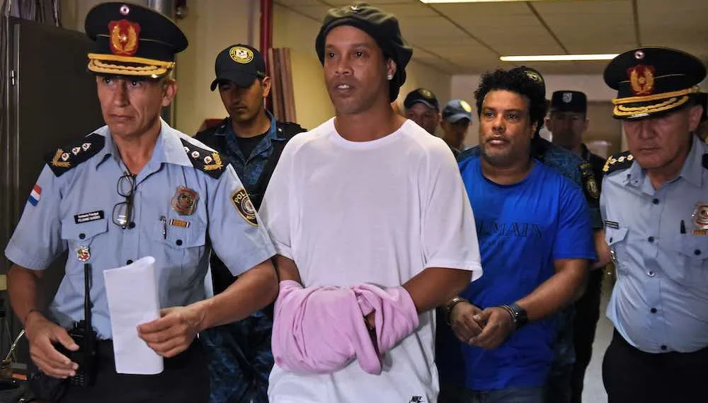 Brazilian retired football player Ronaldinho (C) and his brother Roberto Assis (R) arrive at Asuncion's Justice Palace to appear before a public prosecutor who will decide whether to grant them bail or not following their irregular entry to the country, in Asuncion, on March 7, 2020. - Former Brazilian football star Ronaldinho and his brother have been detained in Paraguay after allegedly using fake passports to enter the South American country, authorities said Wednesday. (Photo by Norberto DUARTE / AFP) (Photo by NORBERTO DUARTE/AFP via Getty Images)