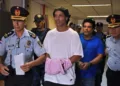 Brazilian retired football player Ronaldinho (C) and his brother Roberto Assis (R) arrive at Asuncion's Justice Palace to appear before a public prosecutor who will decide whether to grant them bail or not following their irregular entry to the country, in Asuncion, on March 7, 2020. - Former Brazilian football star Ronaldinho and his brother have been detained in Paraguay after allegedly using fake passports to enter the South American country, authorities said Wednesday. (Photo by Norberto DUARTE / AFP) (Photo by NORBERTO DUARTE/AFP via Getty Images)