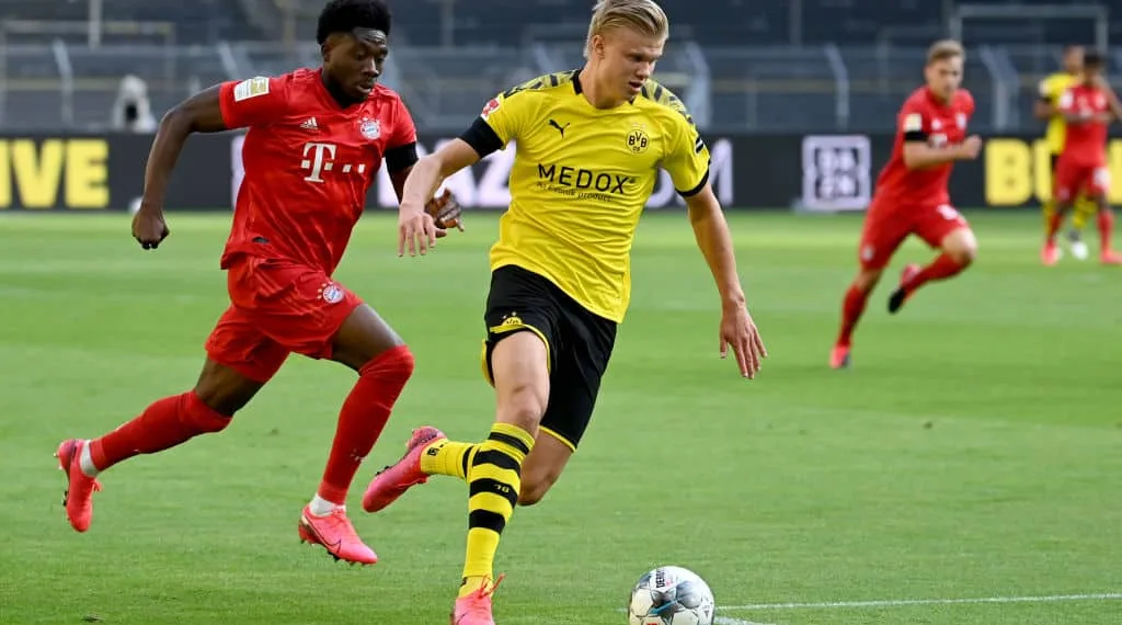 Dortmund's Norwegian forward Erling Braut Haaland (R) and Bayern Munich's Canadian midfielder Alphonso Davies vie for the ball during the German first division Bundesliga football match BVB Borussia Dortmund v FC Bayern Munich on May 26, 2020 in Dortmund, western Germany. (Photo by Federico GAMBARINI / POOL / AFP) / DFL REGULATIONS PROHIBIT ANY USE OF PHOTOGRAPHS AS IMAGE SEQUENCES AND/OR QUASI-VIDEO (Photo by FEDERICO GAMBARINI/POOL/AFP via Getty Images)