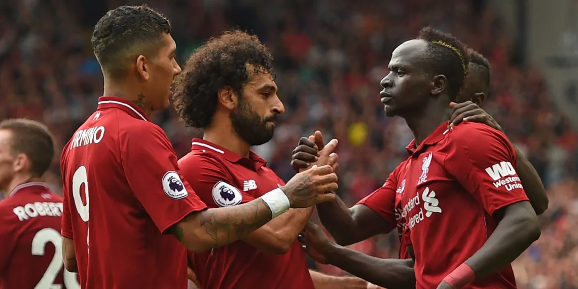 Liverpool's Senegalese striker Sadio Mané (R) celebrates with teammates after scoring their third goal during the English Premier League football match between Liverpool and West Ham United at Anfield in Liverpool, north west England on August 12, 2018. (Photo by Oli SCARFF / AFP) / RESTRICTED TO EDITORIAL USE. No use with unauthorized audio, video, data, fixture lists, club/league logos or 'live' services. Online in-match use limited to 120 images. An additional 40 images may be used in extra time. No video emulation. Social media in-match use limited to 120 images. An additional 40 images may be used in extra time. No use in betting publications, games or single club/league/player publications. / (Photo credit should read OLI SCARFF/AFP/Getty Images)