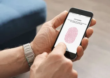 Kiev Ukraine - March 06 2016: Man using touch ID scanner of fingerprints on iPhones 6 developed by Apple corporation. Allows users to unblock the smartphone and to make purchases.