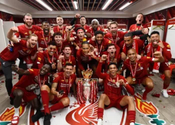 LIVERPOOL, ENGLAND - JULY 22: (THE SUN OUT, THE SUN ON SUNDAY OUT) Trent Alexander-Arnold, Georginio Wijnaldum, Naby Keita, Roberto Firmino, Alex Oxlade-Chamberlain, Fabinho, Andy Robertson, Virgil van Dijk, James Milner, Joe Gomez, Curtis Jones, Adrian, Divock Origi, Adam Lallana, Harvey Elliott, Joel Matip, Xherdan Shaqiri, Jordan Henderson captain of Liverpool and Jurgen Klopp manager of Liverpool celebrating in the dressing room with the premier league trophy after winning the Premier league at the end of the Premier League match between Liverpool FC and Chelsea FC at Anfield on July 22, 2020 in Liverpool, England. Football Stadiums around Europe remain empty due to the Coronavirus Pandemic as Government social distancing laws prohibit fans inside venues resulting in all fixtures being played behind closed doors. (Photo by Andrew Powell/Liverpool FC via Getty Images)