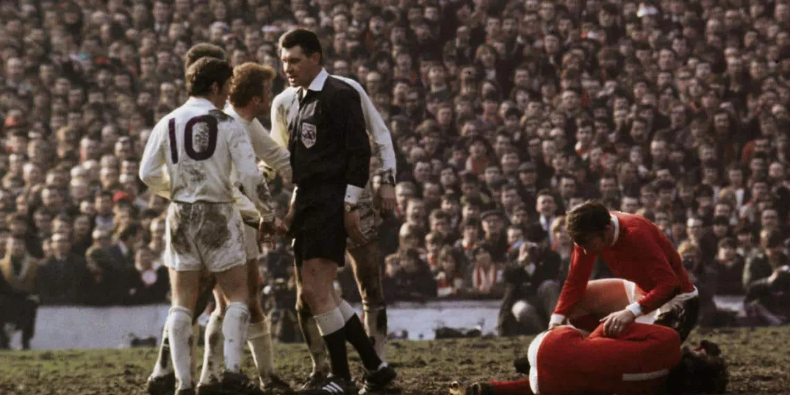 1970:  Referee Jack Taylor talks to Leeds United's Billy Bremner (1942 -1997) as Manchester United's Pat Crerand attends to injured team mate George Best.  (Photo by A. Jones/Express/Getty Images)