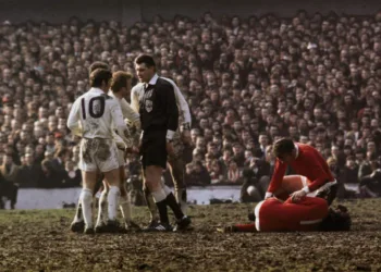 1970:  Referee Jack Taylor talks to Leeds United's Billy Bremner (1942 -1997) as Manchester United's Pat Crerand attends to injured team mate George Best.  (Photo by A. Jones/Express/Getty Images)