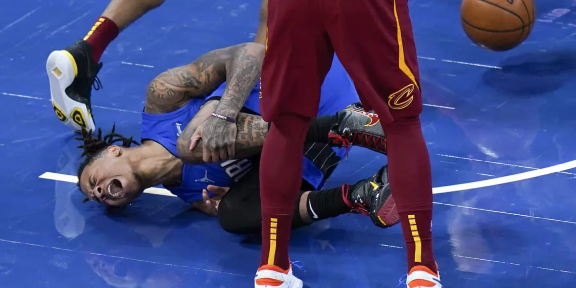 Markelle Fultz falls in pain, holding his left leg.