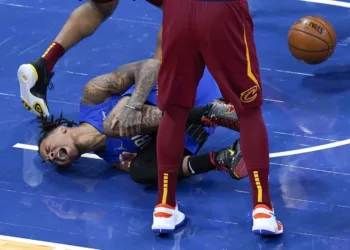 Markelle Fultz falls in pain, holding his left leg.