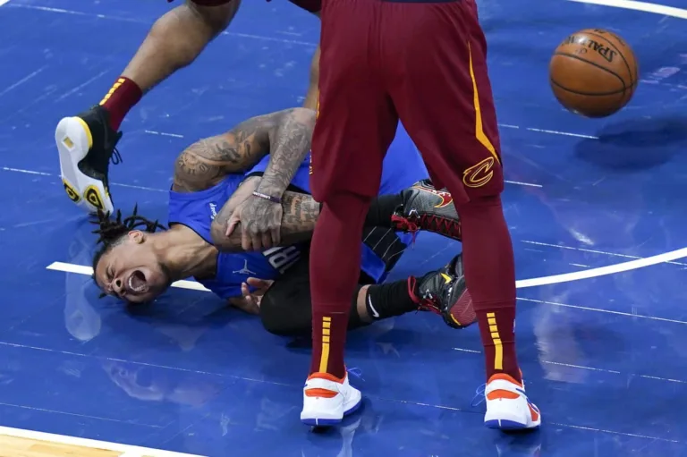 Markelle Fultz falls in pain, holding his left leg.