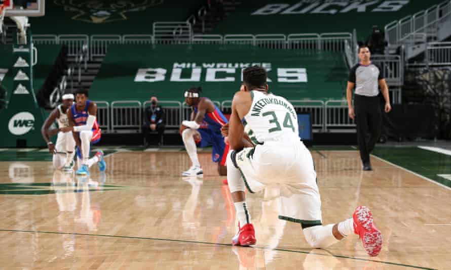 NBA players kneel down during their match.