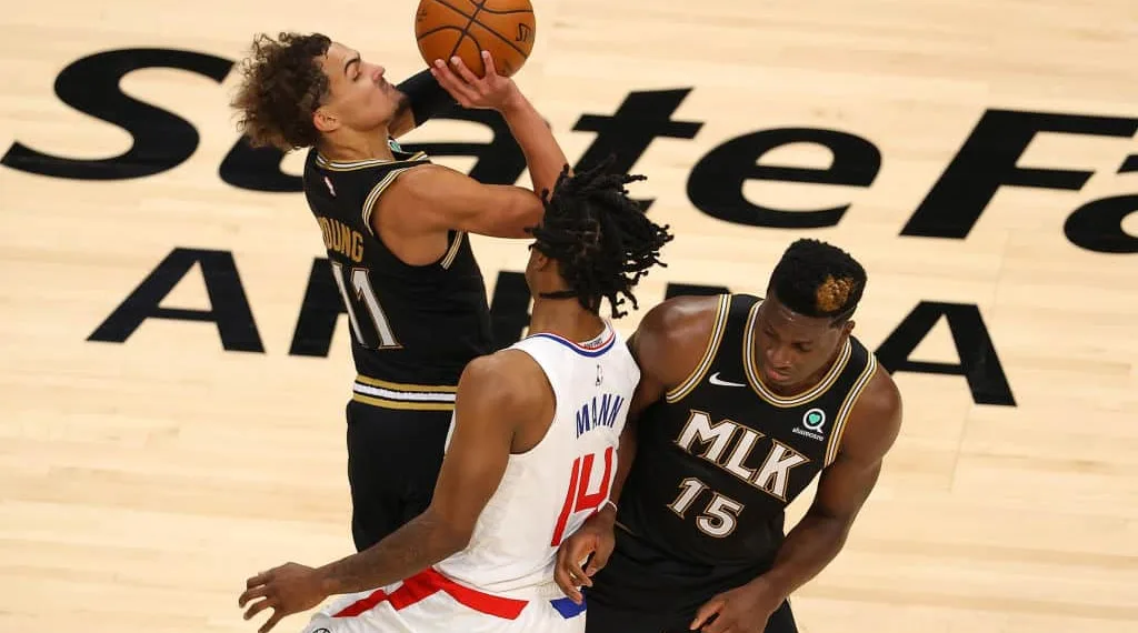 ATLANTA, GEORGIA - JANUARY 26: Trae Young #11 of the Atlanta Hawks attempts a shot as he draws a foul from Terance Mann #14 of the LA Clippers during the second half at State Farm Arena on January 26, 2021 in Atlanta, Georgia. NOTE TO USER: User expressly acknowledges and agrees that, by downloading and or using this photograph, User is consenting to the terms and conditions of the Getty Images License Agreement. (Photo by Kevin C. Cox/Getty Images)