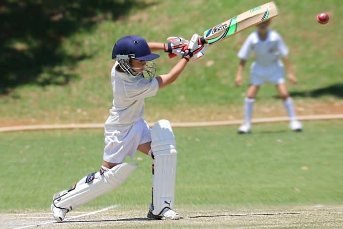 man in white jersey shirt and pants holding cricket bat