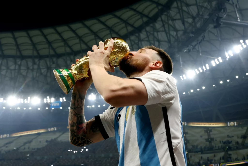 Lionel Messi with the World Cup Trophy Image via Reuters Lionel Messi's Historic 2022 FIFA World Cup Winning Jerseys Ignite Unprecedented Bidding Frenzy