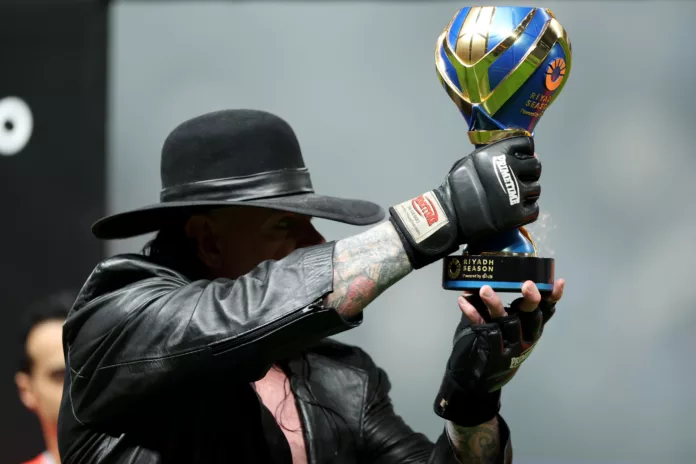 WWE's, The Undertaker presented the Riyadh Season Trophy to the victor of the Al-Hilal versus Al-Nassr match, Image Credits- X (Twitter) WWE's, The Undertaker presented the Riyadh Season Trophy to the victor of the Al-Hilal versus Al-Nassr match, Image Credits- X (Twitter)