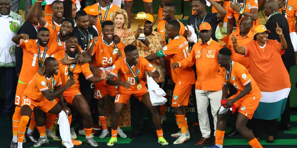 Soccer Football - Africa Cup of Nations - Final - Nigeria v Ivory Coast - Stade Olympique Alassane Ouattara, Abidjan, Ivory Coast - February 11, 2024 Ivory Coast president Alassane Ouattara with the trophy alongside the players as they celebrate after winning the Africa Cup of Nations REUTERS/Siphiwe Sibeko