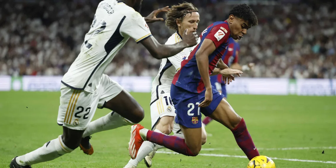 Soccer Football - LaLiga - Real Madrid v FC Barcelona - Santiago Bernabeu, Madrid, Spain - April 21, 2024 FC Barcelona's Lamine Yamal in action with Real Madrid's Antonio Rudiger and Luka Modric REUTERS/Juan Medina