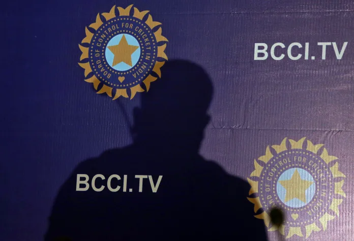 The shadow of a man falls on a backdrop with the logo of the India's cricket board BCCI before the start of a news conference to announce its cricket team's coach, in Mumbai, The shadow of a man falls on a backdrop with the logo of the india's cricket board bcci before the start of a news conference to announce its cricket team's coach, in mumbai,