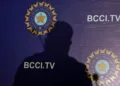 The shadow of a man falls on a backdrop with the logo of the india's cricket board bcci before the start of a news conference to announce its cricket team's coach, in mumbai,
