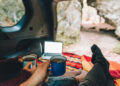 Couple laying in suv car trunk with view of rocky mountains